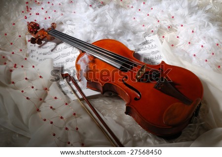 Violin and notes on silk background with boa and furs