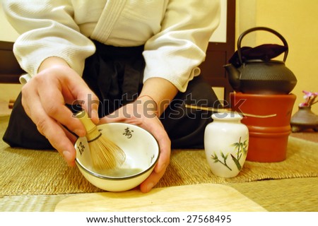 Tools used for Japanese tea ceremony (chado). A brush made of bamboo and a teacup with green tea called matcha on wooden tray. And tea master in kimono.