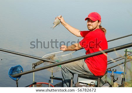 Fisherman holding a bream fish on beautiful river background