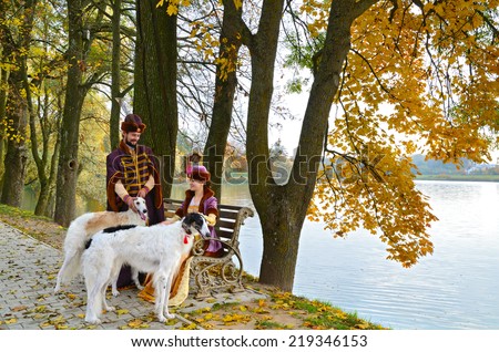 Nesvizh, Belarus - October 12: Couple in medieval costumes of Grand Duchy of Lithuania with Russian psovy borzoi dogs represents everyday life of the nobility in 18-19 centuries on October 12, 2013.