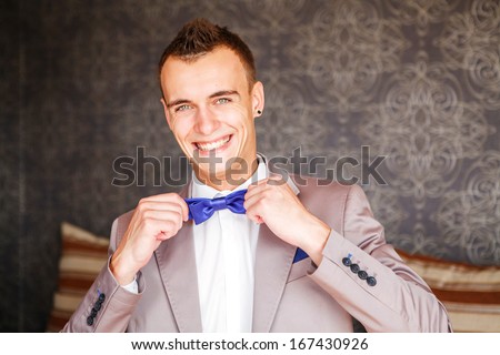 Handsome groom at wedding tuxedo smiling and waiting for bride. Happy smiling groom newlywed. Rich groom at wedding day. Elegant groom in tuxedo costume. Handsome caucasian man in tuxedo.