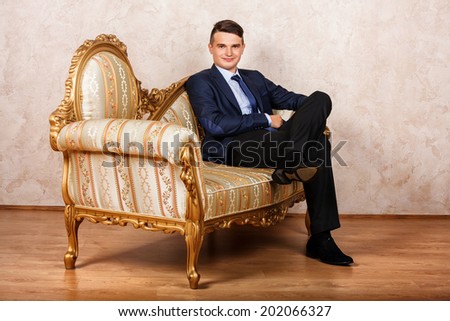 I am a boss. Confident young businessmen in sunglasses sitting on the vintage chair while isolated on grey