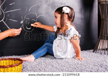 A little girl wrote in chalk on the graphite board. Receive their education.