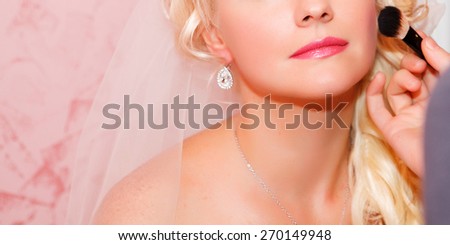 Beautiful bride wedding makeup and hairstyle. Stylist makes makeup bride on wedding day. portrait of young bride at wedding day. series. soft tonality