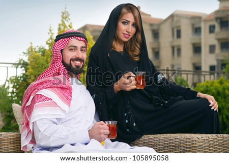 Arabian couple relaxing in the garden and drinking tea