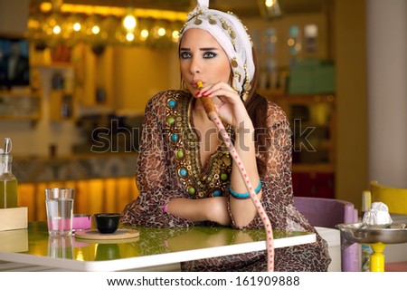 Arabian lady smoking hookah in the coffee shop