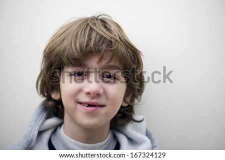 Portrait of a smiling toothless boy on white background