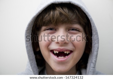 Portrait of a smiling toothless boy on white background