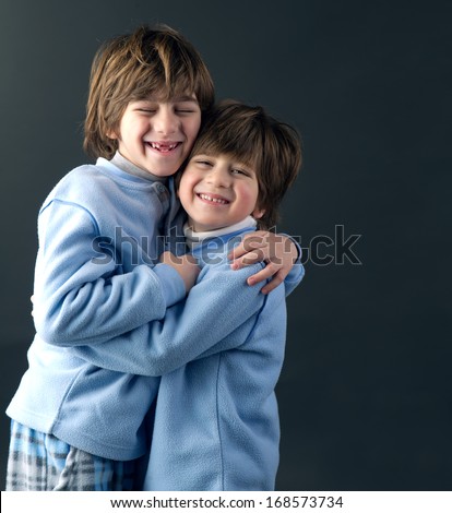Studio portrait of two young brothers hugging and smiling
