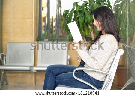 young woman reading brochure in doctor\'s waiting room