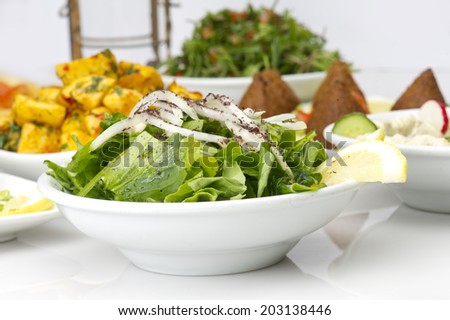 Lebanese food of Arugula Salad, Kibbeh, and Potato cubes