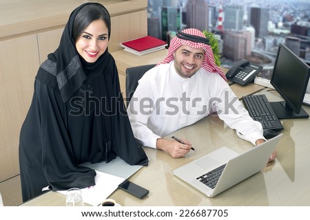Business Meeting in office , arabian businessman & arabian Secretary wearing hijab working on laptop