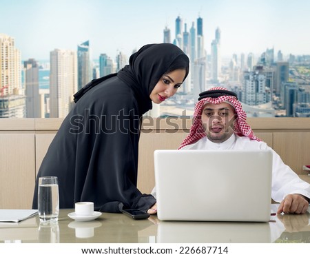 Business Meeting in office , arabian businessman & arabian Secretary wearing hijab working on laptop