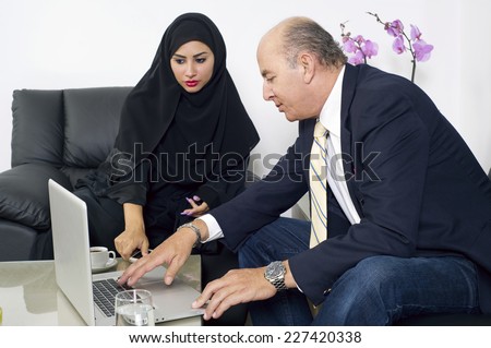 Senior Businessman working with arabian woman wearing hijab in office,