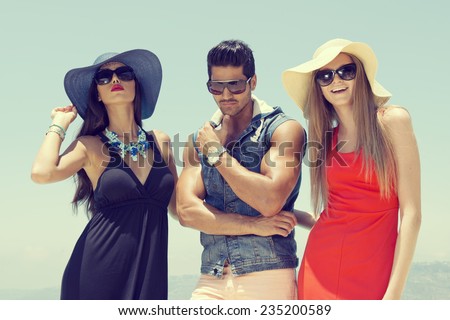 group of friends chatting and having fun at the pool, three stylish friends standing by the pool