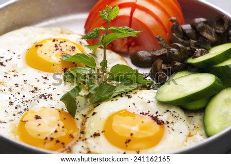Fired eggs presentation with mints, tomato, olive, cucumber and sumac served for breakfast