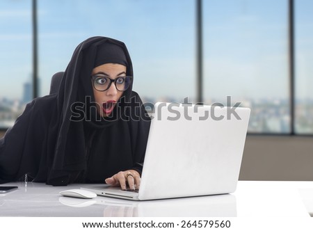 Arabian woman working on her laptop with a shocking expression