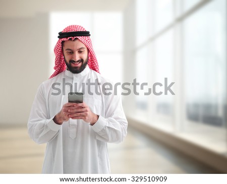 Arab businessman texting in his office