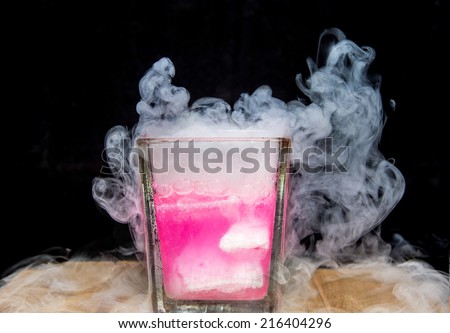 White smoke in glass with dry ice on dark background, pink shade dry ice