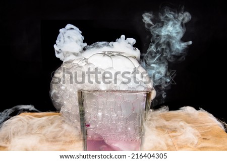 White smoke in glass with dry ice on dark background, pink shade dry ice