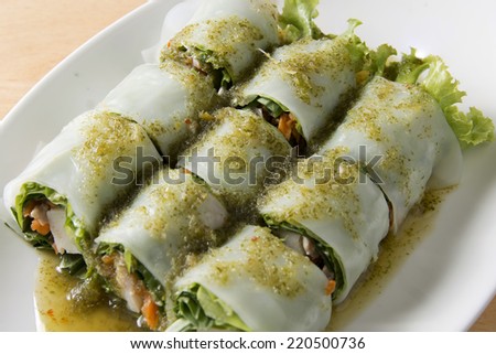 Close up portion of spring rolls on old wood with spicy sauce