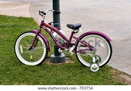 Bike with training wheels locked to a post