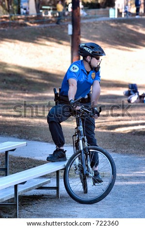 Police officer on a bicycle resting