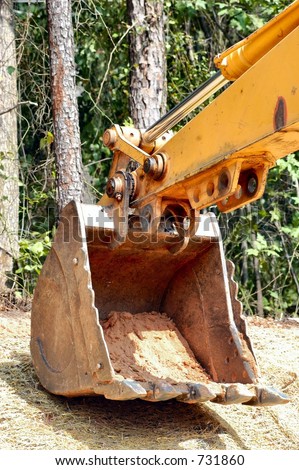 Backhoe Claw resting on a hillside covered in straw
