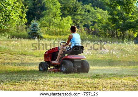 Female on a riding lawn mower cutting the grass