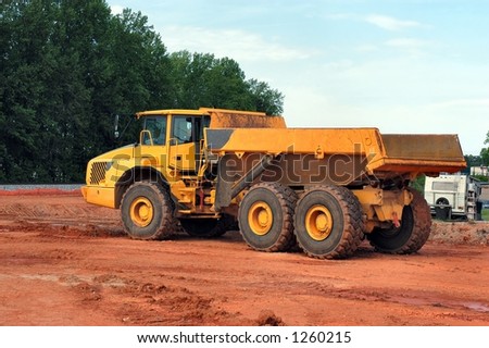Side view of a empty yellow dump truck at rest