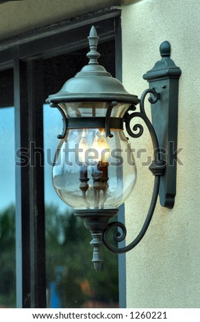 Side view of a Lighted light fixture hanging on a wall.