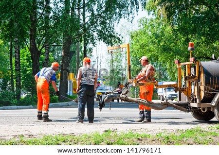 BRYANSK CITY, RUSSIA - JUNE 10: Working people repair the road on June 10, 2013 in Bryansk.  Bryansk is a city and the administrative center of Russia, located 379 kilometers southwest of Moscow.