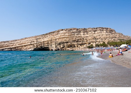 CRETE,GREECE-JULY 22: Tourists on Matala beach with the caves on July 22,2014 Crete island, Greece.