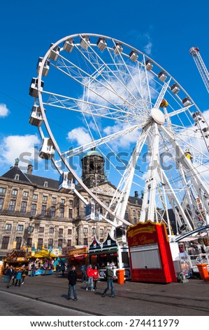 AMSTERDAM-APRIL 27: Ferris wheel on the Dam Square and Royal Palace on the background on the King\'s Day on April 27, 2015, Netherlands. King\'s Day is a national holiday celebrated on April 27th.