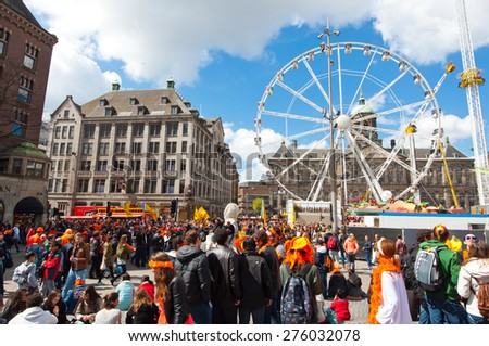 AMSTERDAM-APRIL 27: Dam Square with Ferris wheel and Royal Palace on the background during King\'s Day on April 27, 2015 in Amsterdam. King\'s Day is a national holiday celebrated on April 27th.