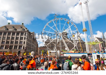 AMSTERDAM,NETHERLANDS-APRIL 27: Dam Square full of people in orange during King\'s Day on April 27,2015 in Amsterdam.  King\'s Day is the largest open-air festivity in Amsterdam.