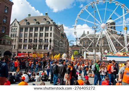 AMSTERDAM,NETHERLANDS-APRIL 27: Dam Square full of people dressed in orange during King\'s Day on April 27,2015 in Amsterdam.  King\'s Day is the largest open-air festivity in Amsterdam.