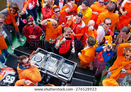 AMSTERDAM,NETHERLANDS-APRIL 27:  People dressed in orange celebrate King\'s Day on a boat on April 27,2015 in Amsterdam.  King\'s Day is the largest open-air festivity in Amsterdam.