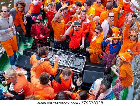 AMSTERDAM,NETHERLANDS-APRIL 27:  People in orange clothes during King\'s Day on a boat on April 27,2015 in Amsterdam.  King\'s Day is the largest open-air festivity in Amsterdam.