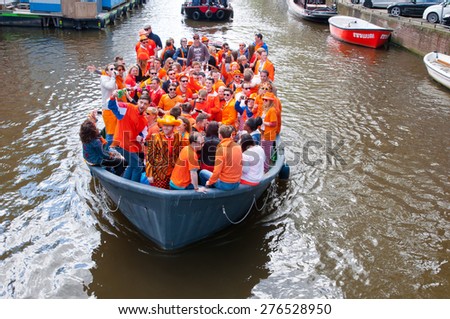 AMSTERDAM,NETHERLANDS-APRIL 27:  Crowd of local people dressed in orange celebrate King\'s Day in a boat on April 27,2015 in Amsterdam.  King\'s Day is the largest open-air festivity in Amsterdam.
