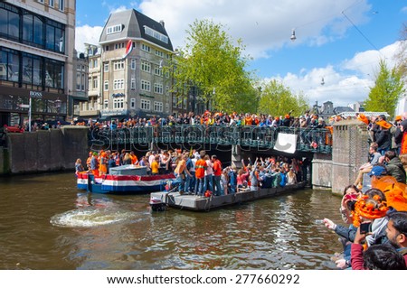 AMSTERDAM-APRIL 27: Singel Amsterdam canal  with crowd of people on the bridge during King\'s Day on April 27,2015. King\'s Day is the largest open-air festivity in Amsterdam, the Netherlands.