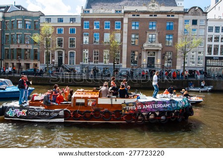 AMSTERDAM - APRIL 27: Open air party through Amsterdam canals during King\'s Day on April 27,2015. the Netherlands. Kings Day is the biggest festival celebrating the birth of Dutch royalty.