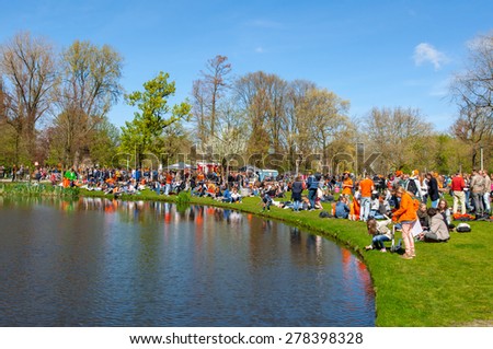 AMSTERDAM-APRIL 27: Crowd of locals and tourists in orange celebrate King\'s Day in on April 27,2015 in Vondelpark. Kings Day is the biggest open-air festival celebrating the birth of Dutch royalty.