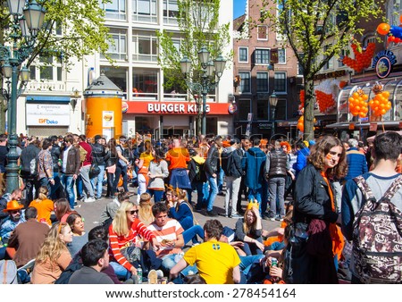 AMSTERDAM-APRIL 27: Crowd of people on Amsterdam street during King\'s Day on April 27,2015 in Amsterdam, the Netherlands. Kings Day is the biggest festival celebrating the birth of Dutch royalty.