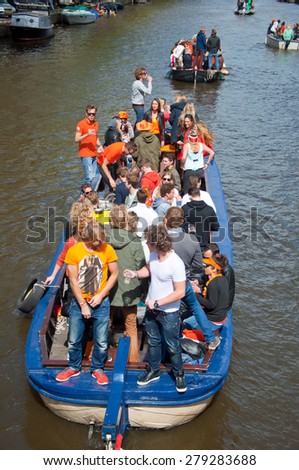 AMSTERDAM-APRIL 27: People on Party Boat with unlimited beer, soda and wine aboard celebrate King\'s Day on April 27,2015. King\'s Day is the largest open-air festivity in Amsterdam.