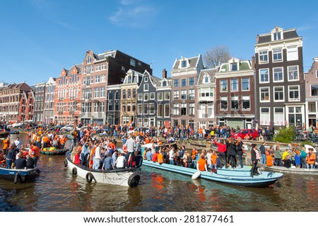 AMSTERDAM-APRIL 27: Locals and tourists on the boats participate in celebrating King\'s Day on April 27,2015 the Netherlands. King\'s Day is the largest open-air festivity in Amsterdam.