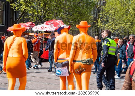 AMSTERDAM-APRIL 27: Locals and tourists in orange take part at celebration Koningsdag (King\'s Day) on April 27,2015, the Netherlands. King\'s Day is the largest open-air festivity in Amsterdam.
