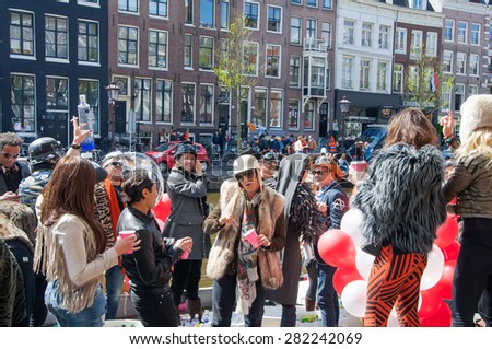 AMSTERDAM-APRIL 27: Town-dwellers celebrate King\'s Day on the Singel canal, April 27,2015 in the Netherlands. King\'s Day is the largest open-air festivity in Amsterdam.