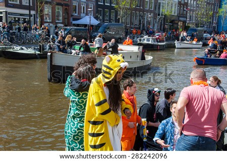 AMSTERDAM-APRIL 27: Locals and tourists solemnize King\'s Day along the Singel canal on April 27,2015. King\'s Day is the largest open-air festivity in Amsterdam.