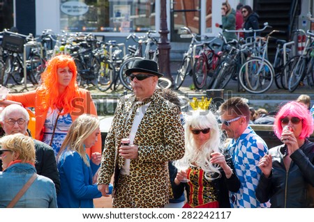 AMSTERDAM-APRIL 27: Unidentified people celebrate King\'s Day along the Singel canal on April 27,2015, the Netherlands. King\'s Day is the largest open-air festivity in Amsterdam.